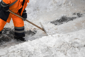 A man with a snow shovel cleans sidewalks in winter. - obrazy, fototapety, plakaty