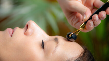 Relaxing benefits of Guasha face massage with a jade stone roller, promoting skin rejuvenation and wellness - 780404729