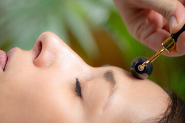 Revitalizing benefits of Guasha facial massage with a jade stone roller, promoting circulation and glowing skin. - 780405392