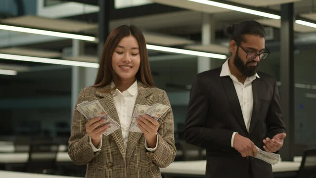 Inequality money equal Asian happy rich wealth businesswoman Chinese woman worker in office counting many banknotes financial profits finance injustice sad poor Indian businessman man envy little cash