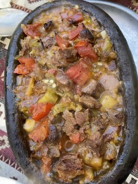 Turkish dish sizzling hot meat with vegetables in a clay pot