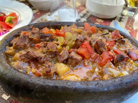 Turkish dish sizzling hot meat with vegetables in a clay pot