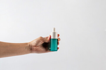 Blue glass cosmetic bottle in hand, Skin care or sunscreen cosmetic on white background.