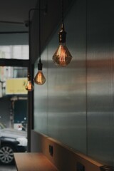 Vertical shot of the hanging lamps in an empty cafe.