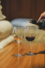 Two glasses filled with red wine, in a cozy apartment 