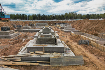 A row of cement blocks stand tall on a dirt field, laying the groundwork for future construction...