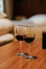 Two glasses filled with red wine, in a cozy apartment 