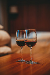 Two glasses filled with red wine, in a cozy apartment 