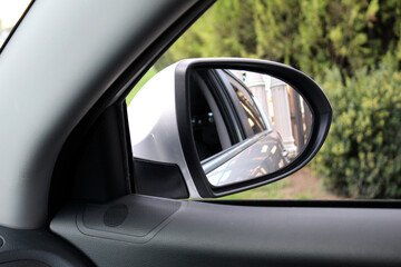 Inside view of car mirror. Look in the rear view mirror of a car. Side rear-view mirror on a car.