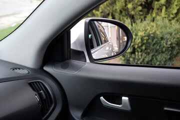 Inside view of car mirror. Look in the rear view mirror of a car. Side rear-view mirror on a car.