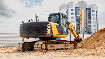 A massive construction machine towering over a busy worksite, surrounded by workers and equipment,...