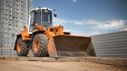 A powerful bulldozer is parked in front of a weathered building, ready for action