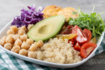 Healthy salad with avocado,lettuce,tomato and chickpeas on wooden table