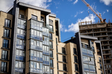 Construction of modern multi-storey residential buildings. City blocks in a big city. View of tall buildings and construction tower cranes