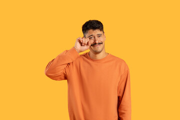 Man with moustache wiping tears on yellow background