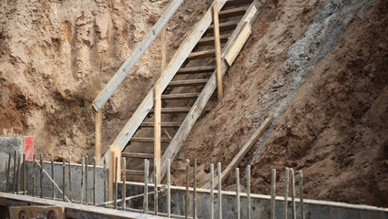 Descent into a deep pit during the construction of the building. Safety in construction. Ladder for...