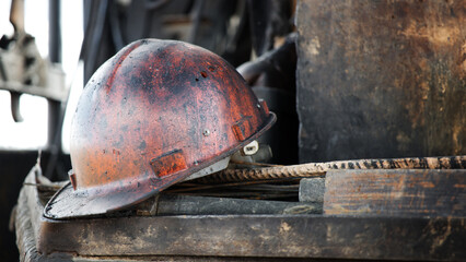 The protective helmet of an oil worker is stained with oil and fuel oil. Extraction of oil and...