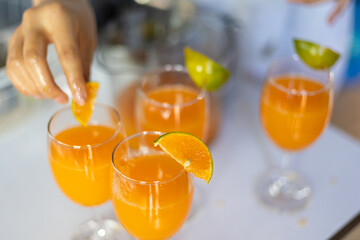 selective focus tangerine slices on the lip of a glass of freshly squeezed orange juice Fresh fruit juice drinks from the orange orchard to taste orange juice.
