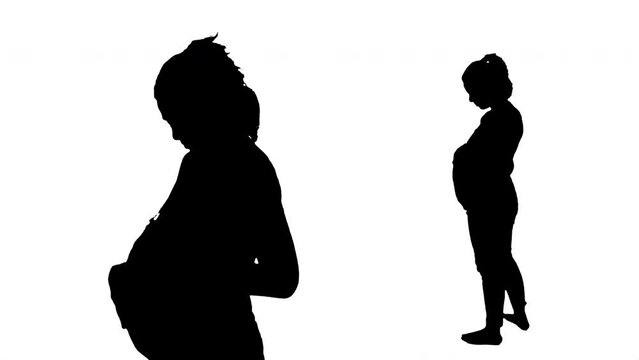 Pregnant Girl Silhouette Cuddles Belly Medium Full Body Shot. Silhouette of a pregnant girl cuddling her belly. Medium and large shot