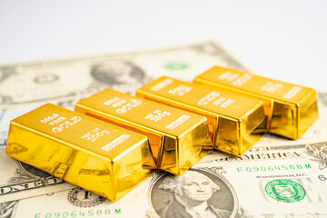 Gold bar on US dollar banknotes money and graph, economy finance exchange trade investment concept.