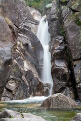 Vertical shot of the flowing rocky waterfall in Peneda-Geres National Park in Portugal