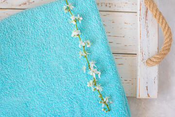 cherry blossom branch and turquoise towel on a white wooden background. spa and freshness atmosphere - 780419939