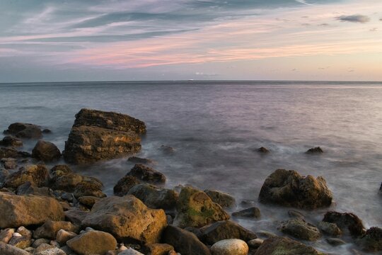Scenic shot of big stones on the shore of the sea on the Isle of Wight at sunset
