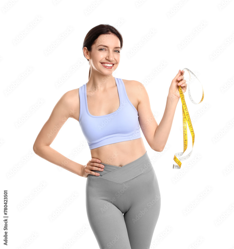 Wall mural Happy young woman with measuring tape showing her slim body against white background