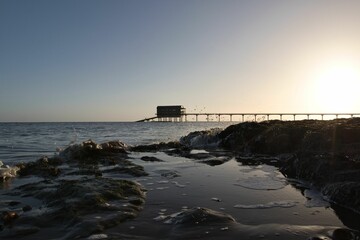 Fototapeta premium Bembridge beach and its lifeboat station in the Isle of Wight against the cloudless sky