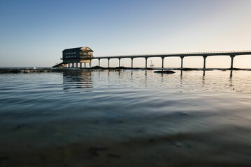 Bembridge beach and its lifeboat station in the Isle of Wight against the cloudless sky