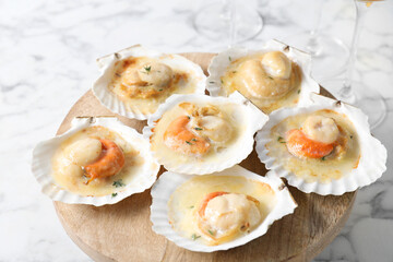 Fried scallops in shells on white marble table, closeup