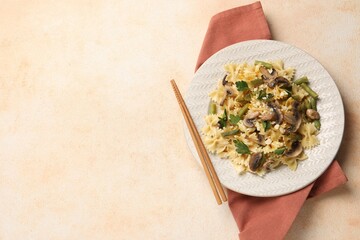 Vegetarian pasta with mushrooms, parsley, string beans and cheese on orange textured table, top...