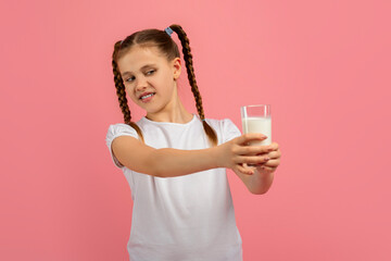 Contemplative girl looking at glass of milk