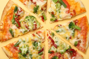 Delicious vegetarian pizza on yellow table, top view