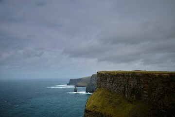 Scenic view of the evergreen Cliffs of Moher in Ireland on a gloomy day