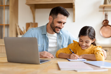 Man helping young girl with homework at home