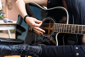 Rock guitarist woman playing with an acoustic guitar
