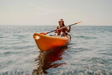 Kayak sea woman. Happy attractive woman with long hair in red swimsuit, swimming on kayak. Summer holiday vacation and travel concept.