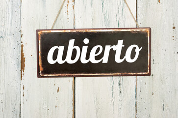 Vintage tin sign on a wooden background - Open in spanish - 780434722