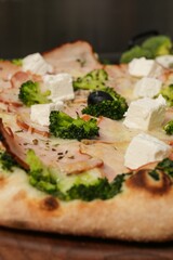 Vertical closeup shot of details on a gourmet pizza with broccoli and cheese toppings