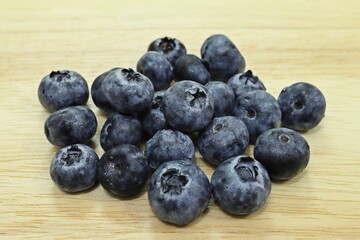 Blueberries on wood plate background close up