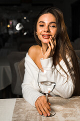Young woman drinks clean water from a glass in a restaurant.Healthy food concept 