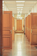 Vertical shot of open wooden doors in a long corridor