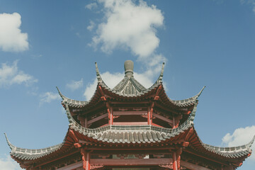 Fototapeta premium Top of an Asian building against the blue cloudy sky
