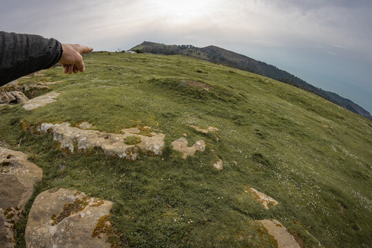 hand showing on a mountain pic, with fish eye effect