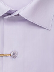 Close-up of a button placket on a light purple men's dress shirt, top view