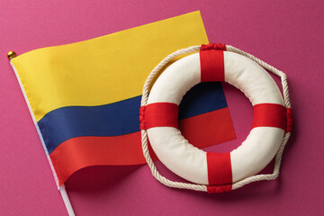 Colombian flag and lifebuoy on a colored background, concept on the theme of help