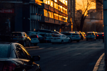 Sunset orange light reflecting on cars in the urban street