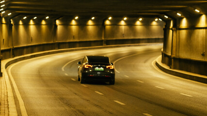 Modern car driving in a modern tunnel at night with lights