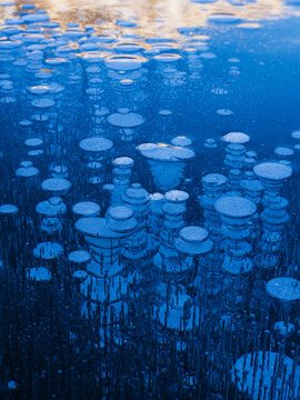 High angle view of bubbles inside frozen lake forming natural pattern